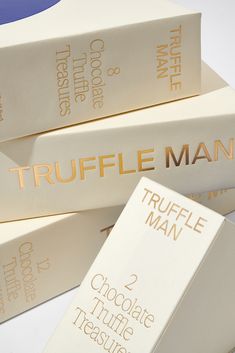 three truffle man chocolates stacked on top of each other in white boxes