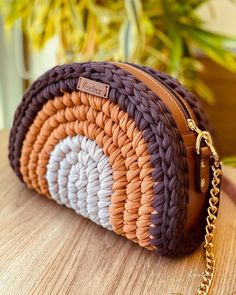 a brown and white purse sitting on top of a wooden table