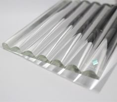 several silver colored toothbrushes lined up on a white surface