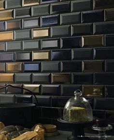 the kitchen counter is covered with bread and pastries in front of a mosaic tile backsplash