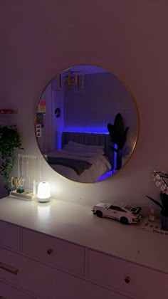 a white dresser topped with a round mirror