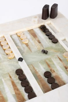 a marble board game with buttons and dices on the table next to each other