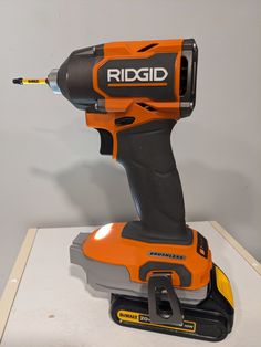 an orange and black cordless drill is on display