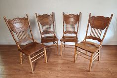 four wooden chairs sitting on top of a hard wood floor