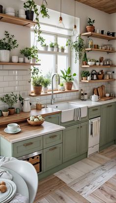 a kitchen filled with lots of green plants and wooden counter tops next to a window