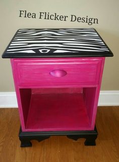 a pink and black side table with zebra print on the top, in front of a wall that says flea flickr design