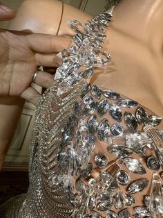 the back of a woman's dress is covered in crystal stones