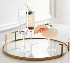 two champagne glasses on a tray with an apple and rosemary garnish