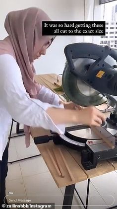 a woman is using a circular saw to cut some material on a table with a machine in front of her