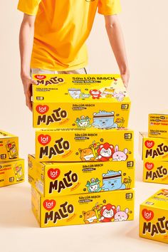 a man is standing in front of many boxes of mako to match game cards