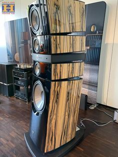 the speakers are stacked on top of each other in front of a wood flooring