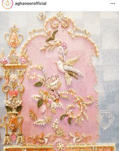 there is a pink and gold wall hanging with birds on it, along with other decorative items