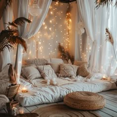 a bed with lots of pillows and lights on the wall in front of it's headboard