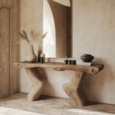 a wooden table sitting in front of a mirror on top of a wall next to a vase