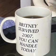 a white coffee mug sitting on top of a glass table