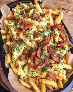 a basket filled with cheesy fries covered in bacon