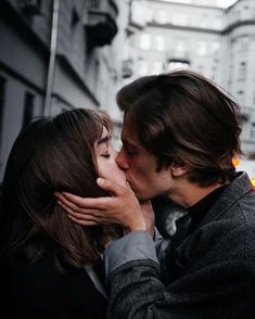 a man and woman kissing in the street