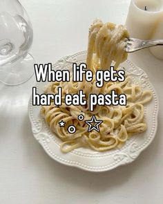 a white plate topped with pasta on top of a table