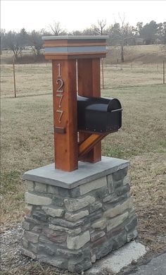 a mailbox sitting on top of a stone pillar