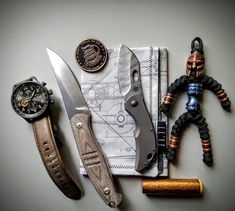 a knife, watch, and other items laid out on a table