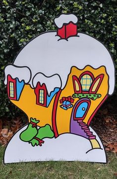 a cardboard cutout of a house with snow on top and trees in the background