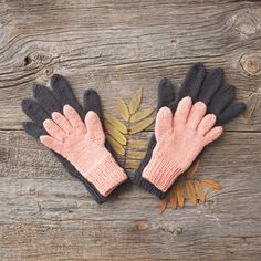 two gloves are sitting on top of a wooden table next to an orange and black plant