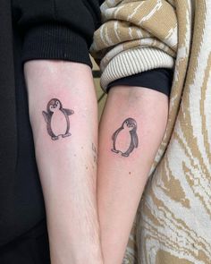 two people with matching tattoos on their legs, one has a penguin and the other has a penguin