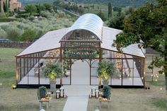 an outdoor wedding venue set up in the middle of a field with greenery and candles