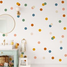 a bathroom with polka dot wall decals and a blue vanity in the foreground