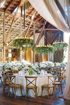 the tables are set with white linens and greenery for an elegant wedding reception