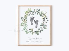 a baby's footprints and leaves print in a wooden frame