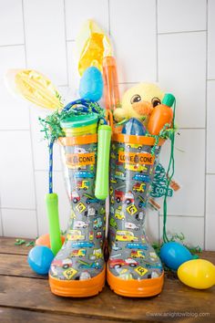 a pair of rain boots sitting on top of a wooden table next to an easter basket