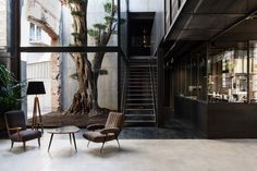 the interior of an apartment building with stairs leading up to the second floor and two chairs on either side