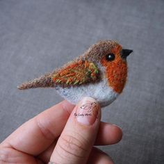 a tiny bird is sitting on someone's finger and it looks like they are holding something in their hand