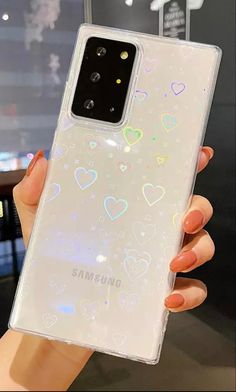 a woman holding up a clear samsung phone case with hearts on the front and sides