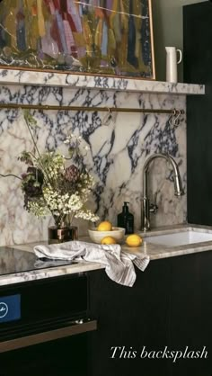 a kitchen with marble counter tops and black cabinets