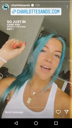 a woman with blue hair is taking a selfie in front of her cell phone