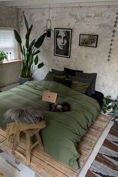 a bed sitting on top of a wooden platform next to a plant in a pot