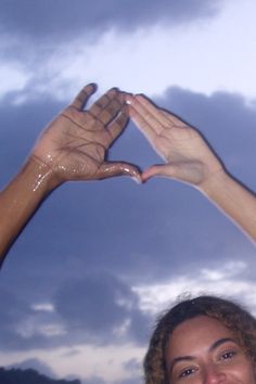 two women are holding their hands in the shape of a heart while smiling at the camera