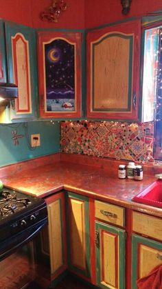 a kitchen with an oven, stove and cabinets painted in different colors on the walls