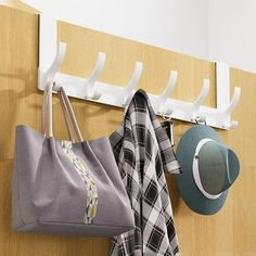 a coat rack with hats and scarfs hanging from it's hooks on a wall