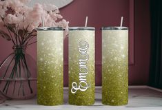 two green glitter tumblers with the word go on them next to some pink flowers