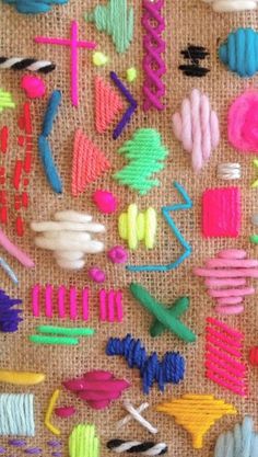 many different colored objects are on the table together, including scissors and stringing needles