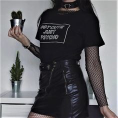 a woman in black shirt and leather skirt holding a cactus