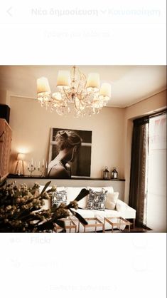 a living room filled with furniture and a chandelier hanging over the top of it