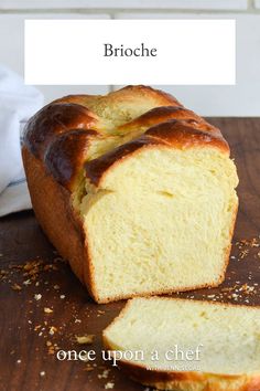 a loaf of bread sitting on top of a wooden table next to a piece of bread