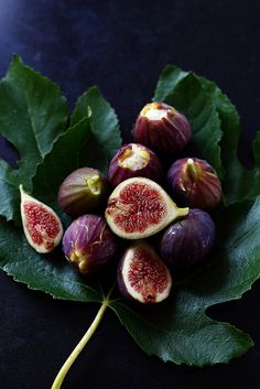 figs with green leaves on a black surface