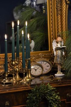 a christmas mantle with candles and an angel figurine next to it, in front of a mirror