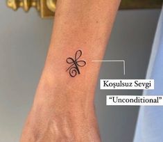 a person with a small tattoo on their wrist and the words, kosuuz seggi unconditionalal