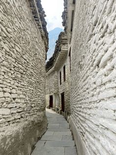 an alley way with stone buildings and cobblestones